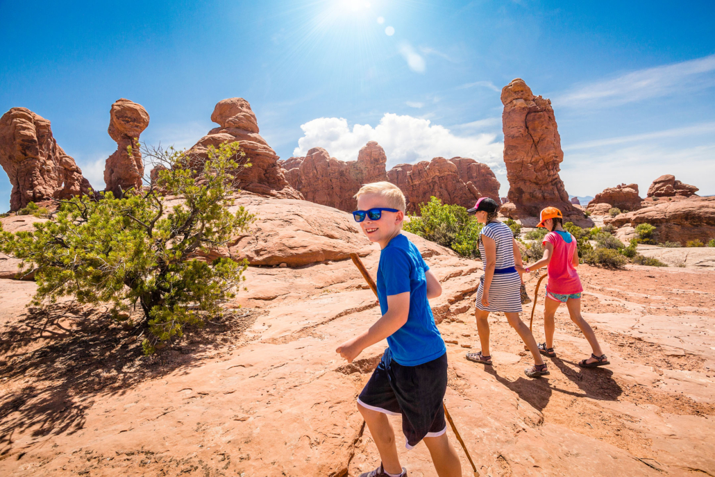 Happy,Family,Hiking,Together,In,The,Beautiful,Rock,Formations,Of Arches National Park