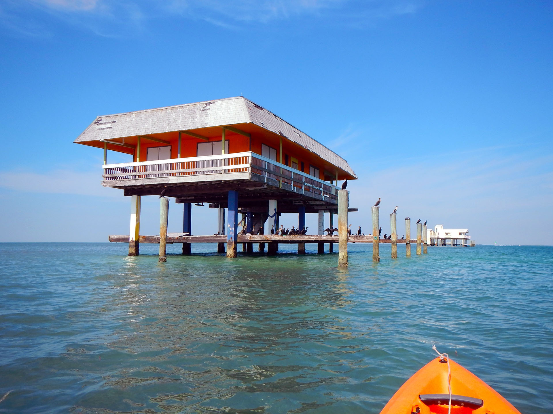 Biscayne_Bay-Two houses of historic Stiltsville in Biscayne Bay with many marine birds seen from an orange kayak._2396169575 Biscayne Bay Two Houses Of Historic Stiltsville In Biscayne Bay With Many Marine Birds Seen From An Orange Kayak