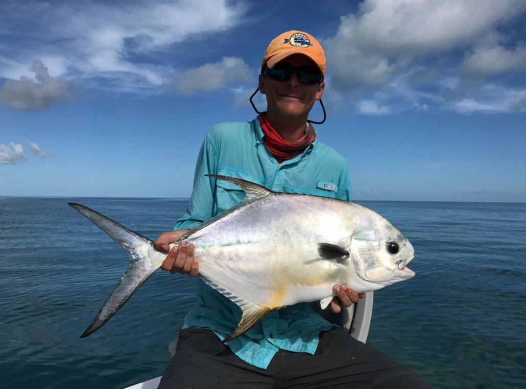 evergladescityfishingcharters_angler-holding-silver-fish-ocean-background-2 Evergladescityfishingcharters Angler Holding Silver Fish Ocean Background
