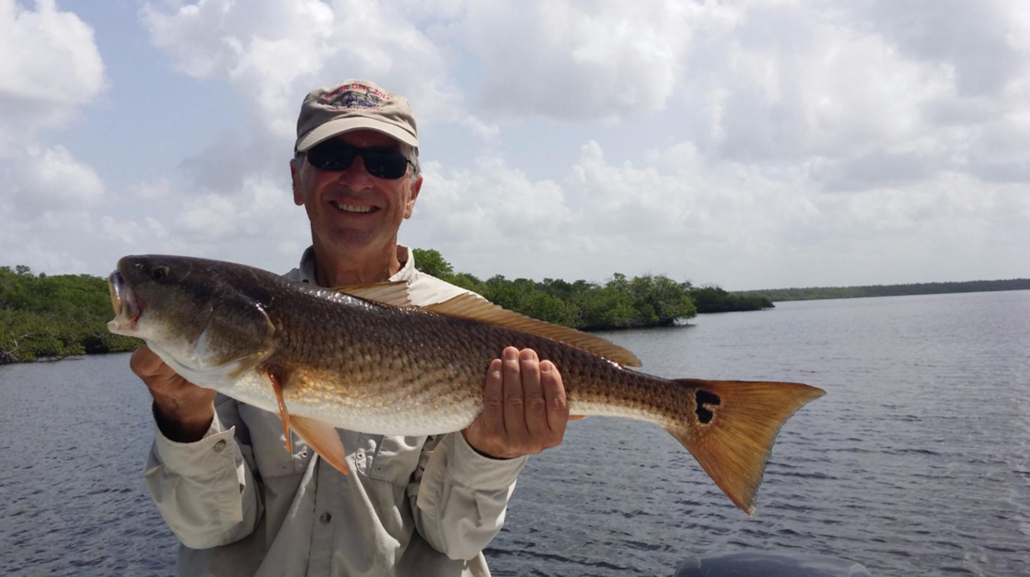 evergladescityfishingcharters_man-holding-redfish-everglades Evergladescityfishingcharters Man Holding Redfish Everglades