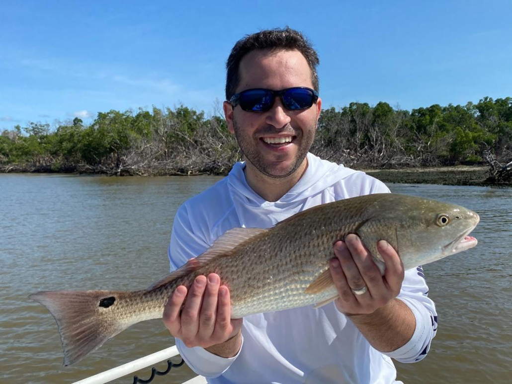 evergladescityfishingcharters_man-holding-redfish-everglades-water Evergladescityfishingcharters Man Holding Redfish Everglades Water