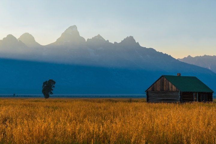rustic, cabin, with, mountains, in, the, distance, during, golden, hour Grizzlycountrywildlifeadventures Rustic Cabin With Mountains In