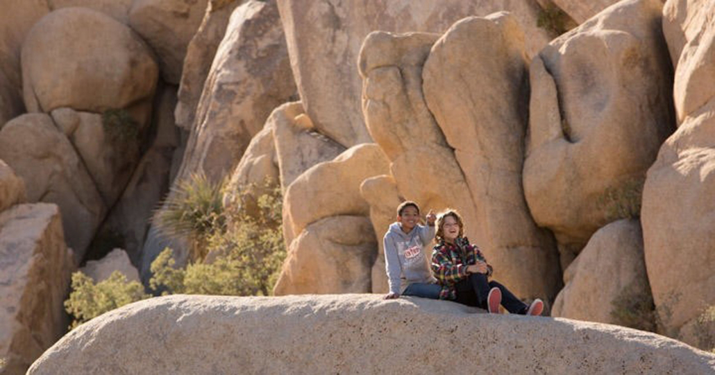 two, friends, relaxing, on, a, rock, formation Red Jeep Two Friends Relaxing On A