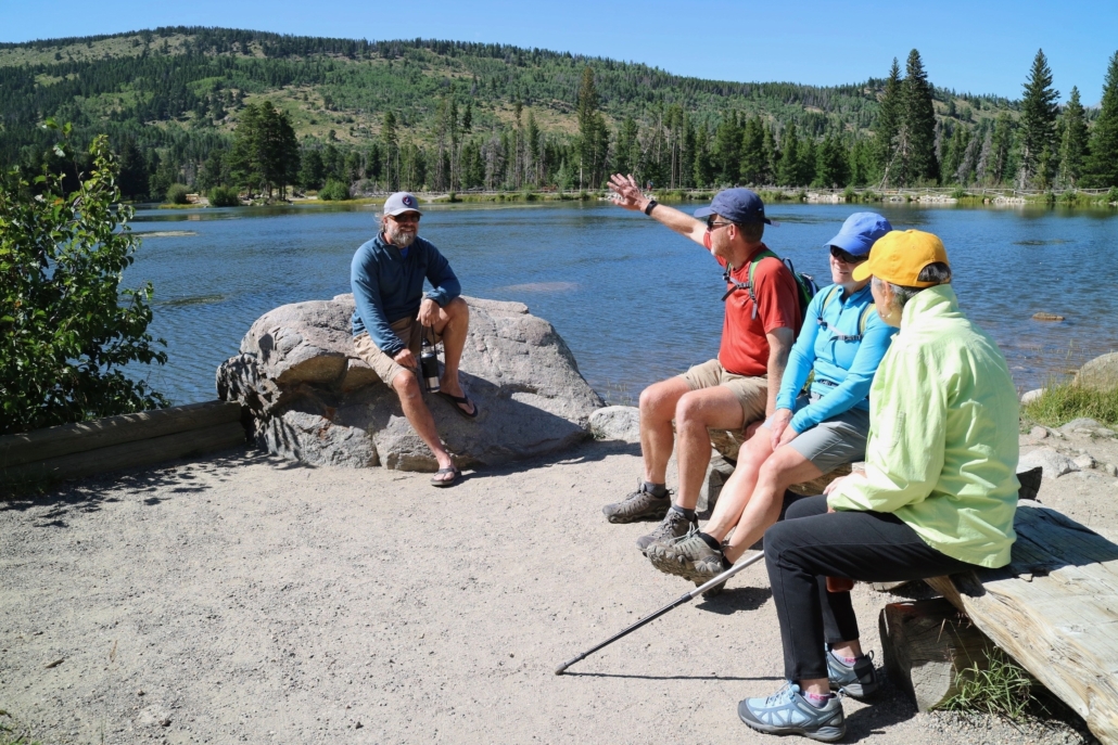 a, group, of, people, enjoying, lakeside, conversation Rockyguides A Group Of People Enjoying