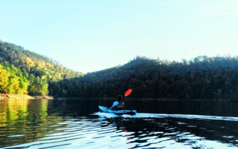 a kayak navigating through calm waters Smokymountainguides A Kayaker Navigating Through Calm