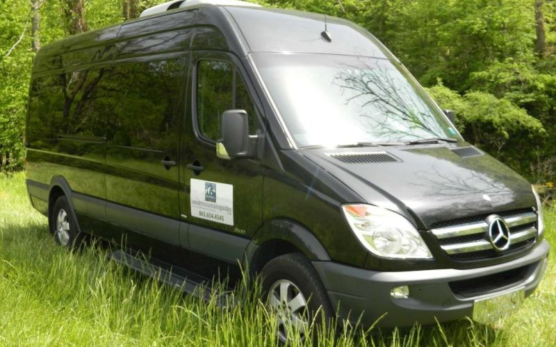 a sleek black van parked in green landscape a sleek black van parked in green landscape