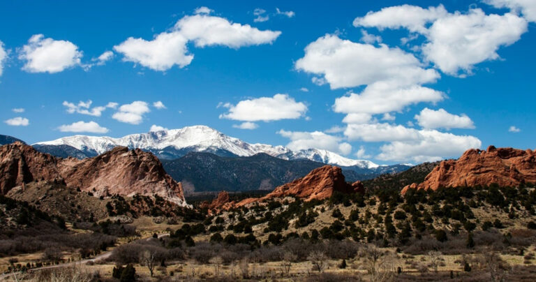 scout-co_seven-falls-and-garden-of-the-gods-snow-capped-mountains-red-rocks-clouds